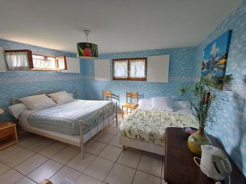 a bedroom with two beds and a table at La Chambre du Bout du Monde in Bouillac