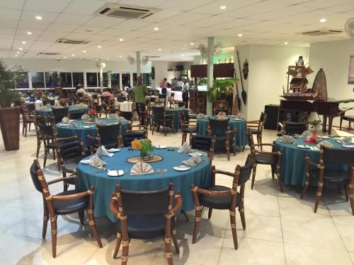 a dining room with blue tables and chairs and a piano at Madang Resort in Madang