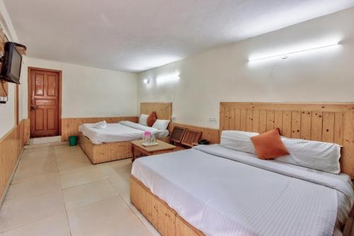 a hotel room with two beds and a couch at Hotel Moonlight Manali in Manāli