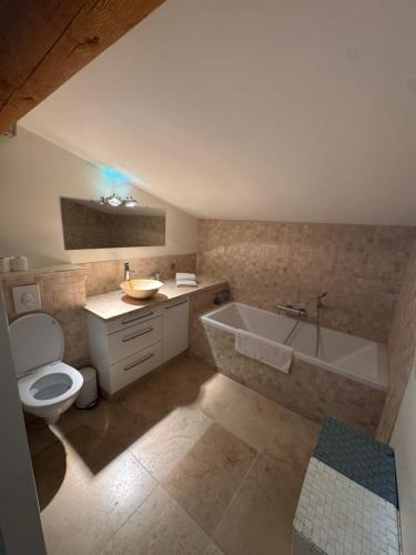 a bathroom with a tub and a toilet and a sink at Villa Bon Cavai in Mornas