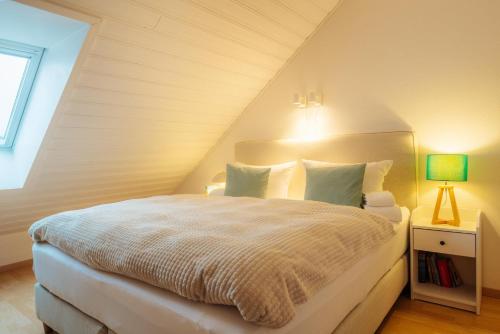 a bedroom with a white bed in a attic at Harzhygge Braunlage in Braunlage