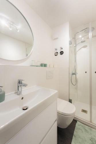 a white bathroom with a sink and a toilet at Harzhygge Braunlage in Braunlage