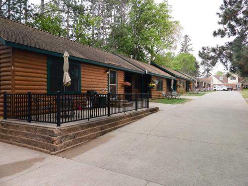a log cabin with a fence in front of it at 2BR 1BA Cabin #7 Riverside Point Resort in Park Rapids