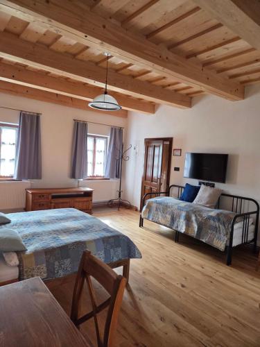 a living room with two beds and a tv at Lotrinský Apartmány in Hodruša