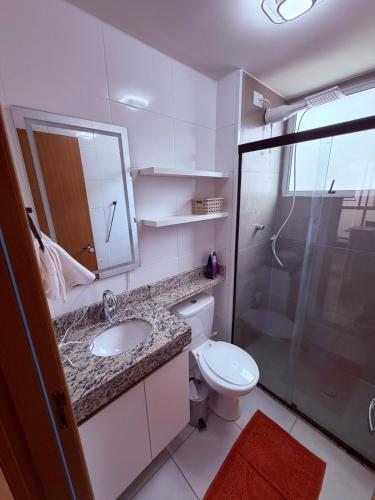 a bathroom with a toilet and a sink and a shower at Espaço inteiro apartamento em Londrina in Londrina