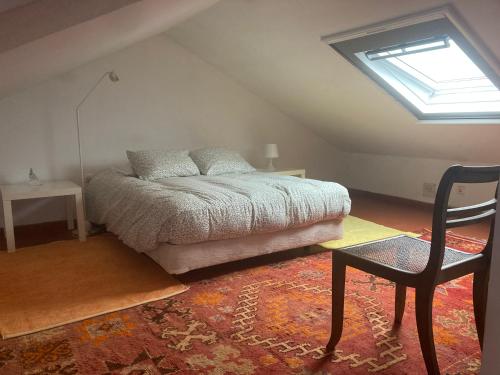 a bedroom with a bed and a chair and a window at Cozy Country House near Beaches in Azoia