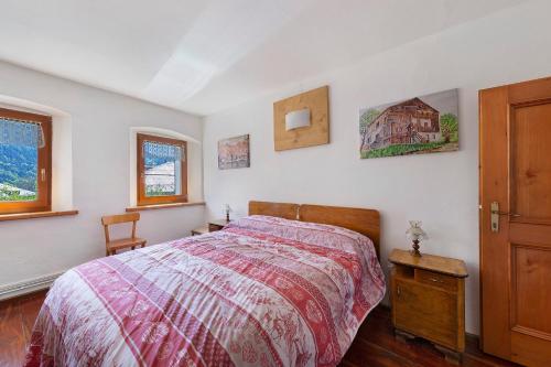 a bedroom with a bed and two windows at Casa Carmen a Vinigo in Vinigo