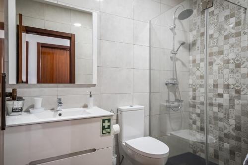 a bathroom with a toilet and a sink and a shower at White Rabbit I by Homie in Calheta