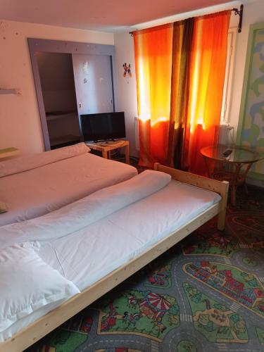 two beds in a room with a television and a table at Cazare muncitori Ploiesti -workers accommodation in Ţînţăreni