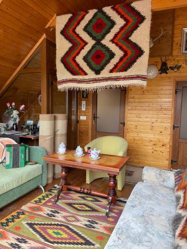 a living room with a table and a rug at Guest house Nad Tisou in Kvasy