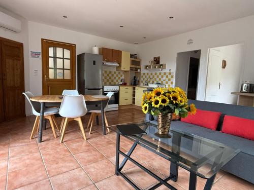 a living room with a couch and a table with flowers at Hacienda in Caumont