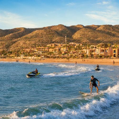 a man riding a wave on a surfboard in the water at a beach at Hôtel Imi Plage in Agadir