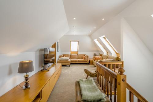 a living room with a staircase with a couch and chairs at 3 Bed in Pitlochry oc-t37864 in Pitlochry