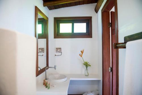 a bathroom with a toilet and a mirror at Pousada Lua Cheia Praia do Espelho in Praia do Espelho