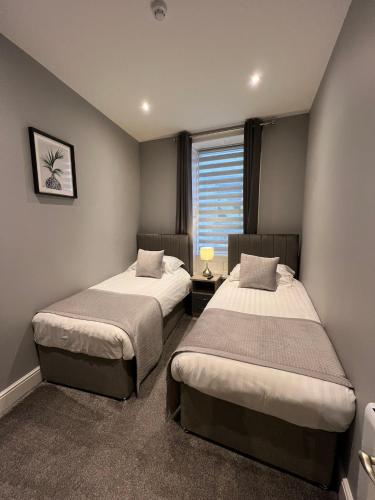 a bedroom with two beds and a window at The Globe Apartments and Bedrooms in Cockermouth