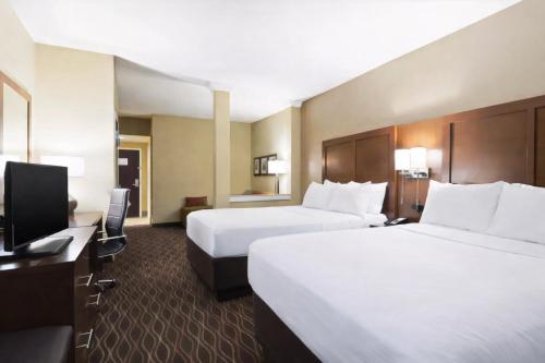 a hotel room with two beds and a television at Tannery Suites in DuBois