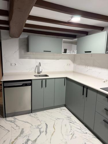 a kitchen with white cabinets and a sink at Malva in Grado