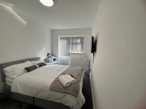 a bedroom with a bed with two towels on it at London Heathrow Uxbridge Escape in Uxbridge