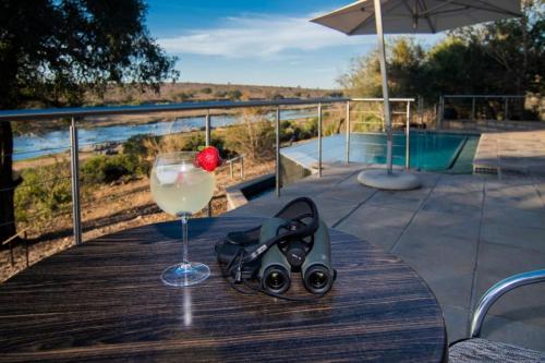 a table with a glass of wine and a pair of scissors at LeoLapa in Hectorspruit