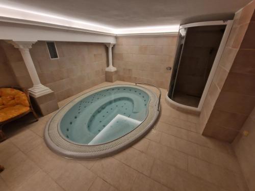 a bathroom with a tub in the middle of a room at Hotel HAVLOV in Žďárec