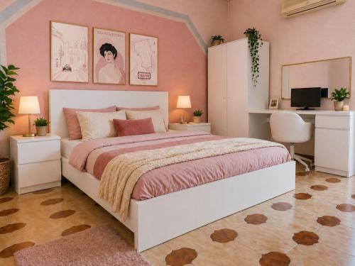 a bedroom with a large bed with pink walls at Torre Florio in Campofelice di Roccella