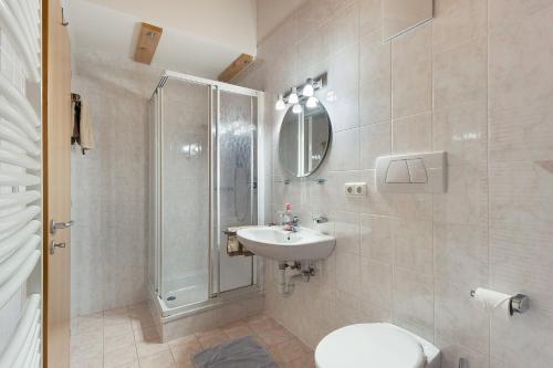 a bathroom with a shower and a toilet and a sink at Getzenbergerhof in Chienes