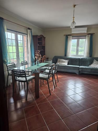 a living room with a table and chairs and a couch at Solar Rubina - Piscina Água Salgada in Belmonte