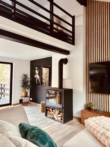 a living room with a fireplace and a couch at Nid cosy en forêt in Blaimont