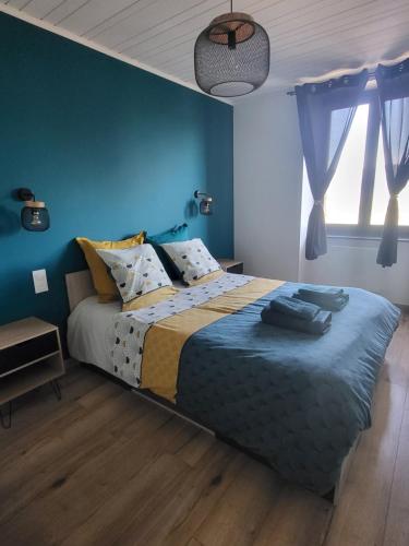 a bedroom with a large bed with blue walls at Logis des Bouchons in Morteau