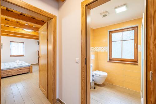 a bathroom with a toilet and a bed at Apartmány Studený in Kunratice