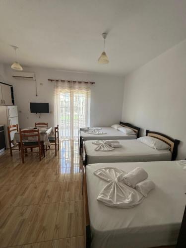 a bedroom with two beds and a dining room at Vila Riviera in Ksamil