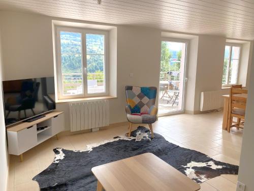 a living room with a chair and a table at La Maison Rose - La Bresse in La Bresse