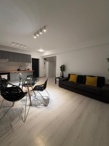 a living room with a black couch and chairs at Otopeni Studios C2 2 Airport Therme in Otopeni