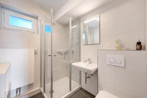 a white bathroom with a shower and a sink at Chalet Seewald - Apartment in Seewald