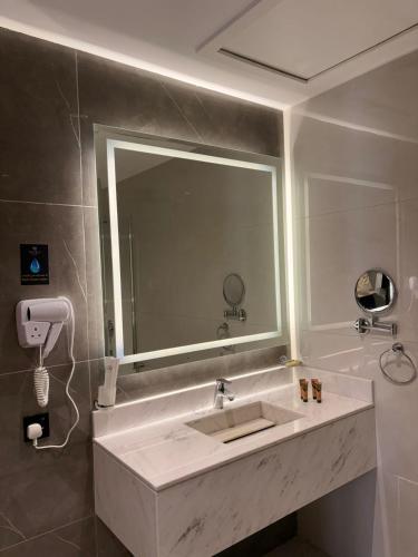 a bathroom with a sink and a large mirror at Mora by jodna - فندق مورا in Al Khobar