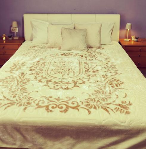 a large bed with a white comforter and pillows at Bistrički mir - Imanje in Bistrica