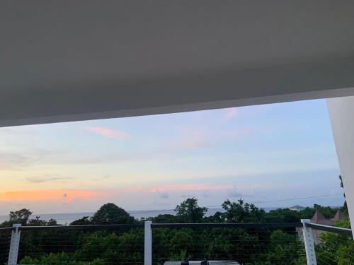 a view of a sunset from a balcony at Purevibe Horizon House Ocean View Villa Port Antonio in Port Antonio