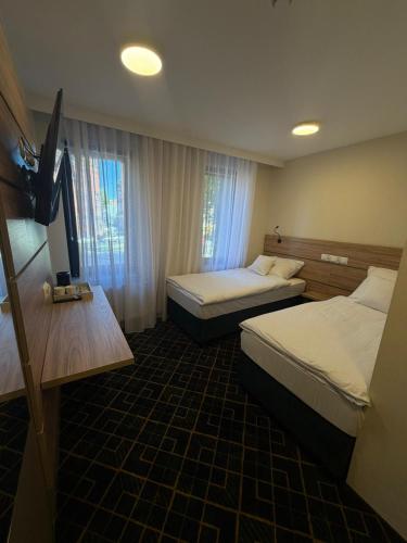 a hotel room with two beds and a television at Royal Apartamenty in Bytom