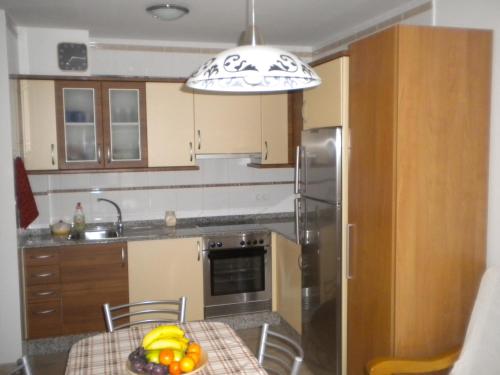 a kitchen with a table with a bowl of fruit on it at Apartamento Ana Sebastián in Lorenzana