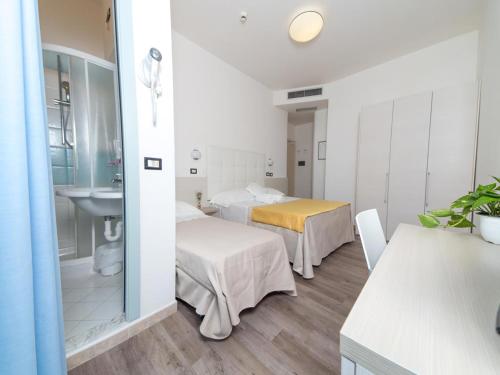 a hotel room with two beds and a sink at Hotel Elite Cattolica in Cattolica