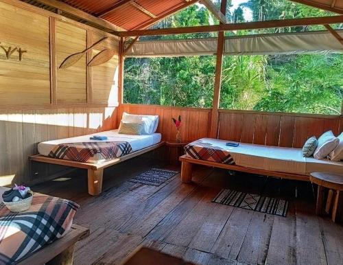 a room with two beds and a wooden floor at Lodge El Amargal - Reserva Natural, Ecoturismo & Surf in Nuquí