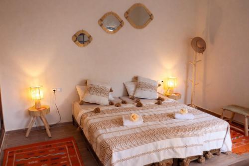 a bedroom with a bed with two mirrors on the wall at Villa Dar Nata in Tougouana