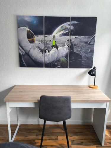 an astronaut in an astronaut ring in the moon picture on a desk at BR Apartment in Kiel