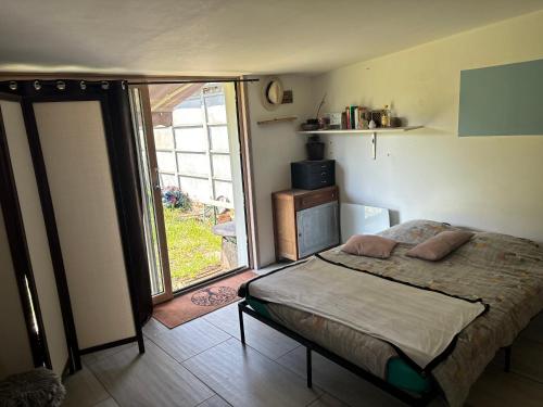 a bedroom with a bed and a large window at Saint varent guest place in Saint-Varent