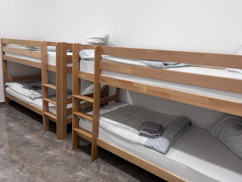 a room with three bunk beds in a room at Hostel N&N in Kula
