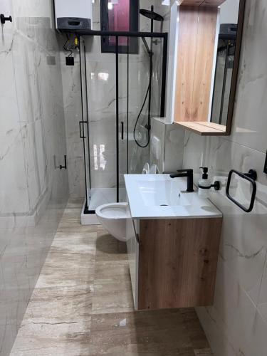 a bathroom with a sink and a shower and a toilet at Hostel N&N in Kula