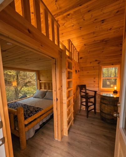 a bedroom in a log cabin with a bed and a desk at Meadowview Springs in Louisville