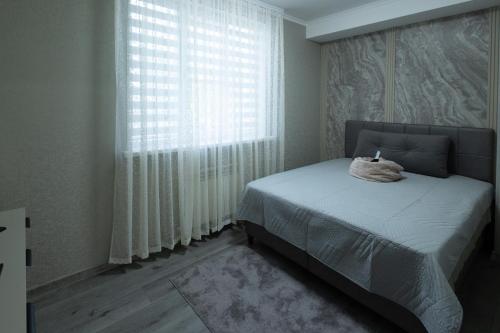 a bedroom with a bed and a large window at Apartaments Miro in Chişinău