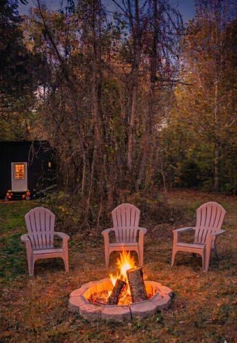 three chairs sitting around a fire in a yard at Meadowview Springs in Louisville