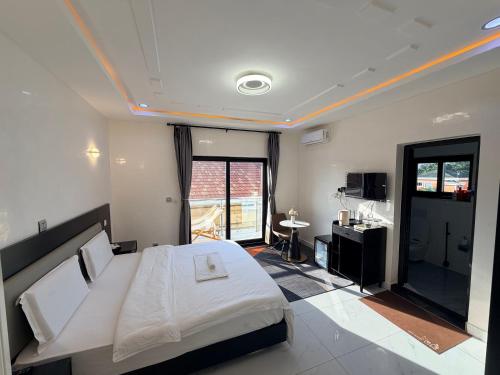 a bedroom with a large white bed and a desk at Easyhome in Brazzaville